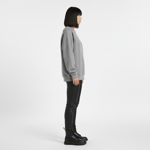 Side view of a woman in an oversized grey crew neck sweatshirt